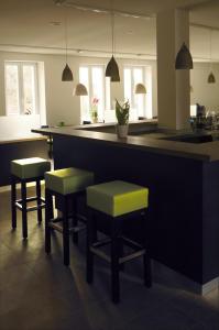 a kitchen with a bar with stools and a counter at Hotel Bahnhof Jestetten in Jestetten