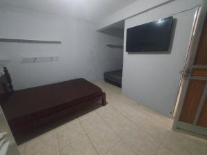 een kleine kamer met een bank en een flatscreen-tv bij Piscina e mar in Angra dos Reis