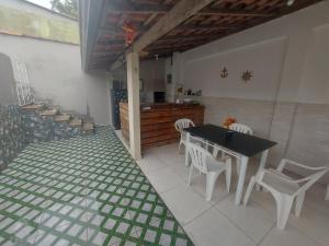 een keuken met een tafel en stoelen en een aanrecht bij Piscina e mar in Angra dos Reis