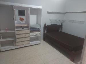 een slaapkamer met een bed en een boekenplank bij Piscina e mar in Angra dos Reis +12 foto's