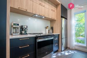 a kitchen with a black stove top oven next to a window at King bed, Cinema screen, Private SPA, Pool, Sauna, Near Quebec in Pont-Rouge +56 photos