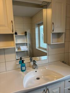 a bathroom with a sink and a mirror at HB HolidayHomes - The White Pearl in Tromsø +8 photos