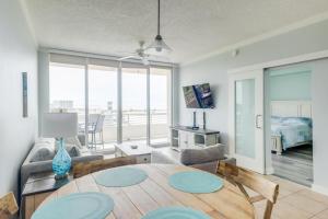a living room with a table and a room with a bed at The Driftwood Oasis in Biloxi