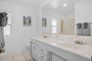 a white bathroom with a sink and a mirror at Oak and Fairway in Riverside +38 photos