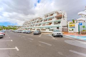 a parking lot with cars parked in front of a building at Ocean Walk Victoria Court 2 Modern in Los Cristianos