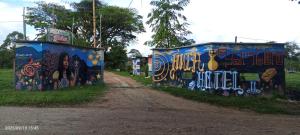 una pared cubierta de grafitis junto a un camino de tierra en Hotel Yamboró, en Pitalito