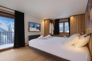 une chambre avec un grand lit avec une grande fenêtre dans l'établissement Chalet Élégance alpine - BO Immobilier - La Chapelle D'Abondance, à La Chapelle-dʼAbondance 22 autres photos