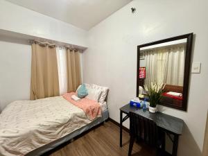 a small bedroom with a bed and a mirror at 1BR LaVerti Cloud Nine Suite Family Affordable Staycation in Manila +35 photos