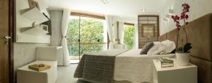 a bedroom with a bed and a large window at Veneza Carioca Hotel Bout in Rio de Janeiro