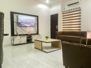 Una televisión o centro de entretenimiento en Oystershell Apartments 1 foto más