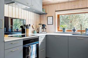 eine Küche mit einem Herd, einem Waschbecken und einem Fenster in der Unterkunft 2706 Nexø - Harevej 11 in Neksø + 15 Fotos