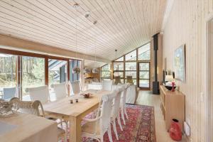 ein Esszimmer mit einem Tisch und weißen Stühlen in der Unterkunft 2706 Nexø - Harevej 11 in Neksø