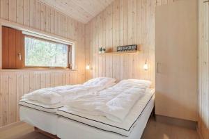 ein großes weißes Bett in einem Zimmer mit Fenster in der Unterkunft 2706 Nexø - Harevej 11 in Neksø