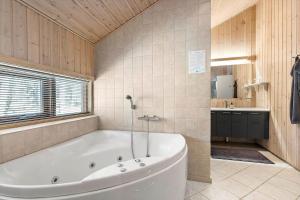 ein großes Badezimmer mit Badewanne und Waschbecken in der Unterkunft 2706 Nexø - Harevej 11 in Neksø