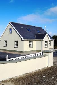 a white house with a black roof at Loophead SelfCatering Cottage SensoryAccessible in Kilrush
