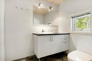a white bathroom with a sink and a mirror at 1465 Aakirkeby - Poseregårdsvejen 5 in Vester Sømarken +13 photos