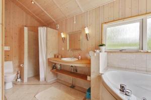 a bathroom with a tub and a sink and a toilet at 3631 Nexø - Turistvej 43 A in Neksø