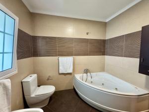 a bathroom with a white tub and a toilet at Vista Ventura in Ponta Delgada +12 photos