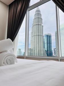 a bedroom with a view of a tall building at Sky Suites KLCC CityLights in Kuala Lumpur