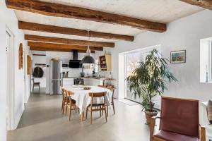 Una cocina y un comedor con mesa y sillas. en 5638 Svaneke - Oksemyrevejen 2 B, en Svaneke