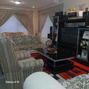 a living room with a couch and a television at Foothill Home 2 in Tsiame +10 photos