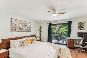 a bedroom with a bed with a ceiling fan and a desk at Rivercourt Condo D2 in Stowe