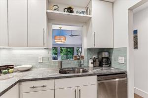 a kitchen with white cabinets and a sink at Rivercourt Condo D2 in Stowe