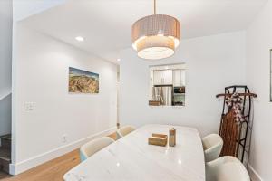 a white dining room with a white table and chairs at Rivercourt Condo D2 in Stowe +20 photos