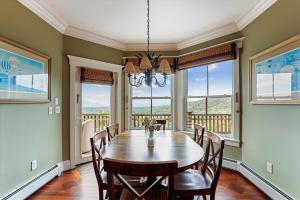 a dining room with a table and chairs and windows at Panorama in Stowe +36 photos