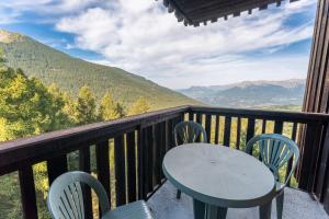 a table and chairs on a balcony with a view at Studio Élégant Les Orres1650 in Les Orres +2 photos