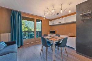 a kitchen and living room with a table and chairs at Studio Élégant Les Orres1650 in Les Orres