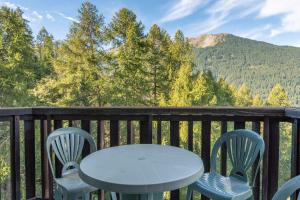 a table and chairs on a deck with mountains at Studio Élégant Les Orres1650 in Les Orres