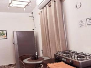 a kitchen with a stove and a refrigerator at Cozy Studio Wkitchen Isla Mujeres Punta Norte in Isla Mujeres