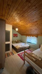 a bedroom with two beds and a wooden ceiling at Te baca Qerim in Lekbibaj