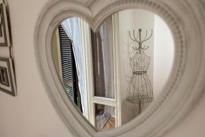 a mirror with a reflection of a dress on a window at La Casa di Brunina - Sentirsi a casa - Con garage auto in Monza