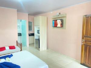 a bedroom with two beds and a tv on the wall at Pousada Villa Sambaqui in Penha