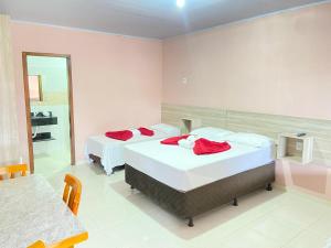 a bedroom with two beds and a mirror at Pousada Villa Sambaqui in Penha +4 photos