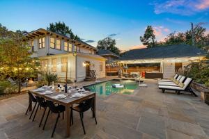 a patio with a table and chairs next to a pool at Pool Outdoor TV Fire Pit Game Room in Memphis