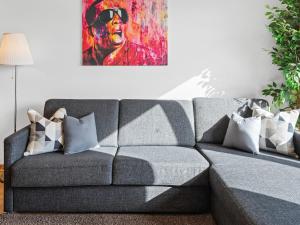 a gray couch in a living room with a painting at Modern City Apartment near Vienna Central Station in Vienna