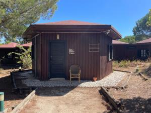 a brown building with a chair in front of it at YMCA Camp Alambre in Azeitao