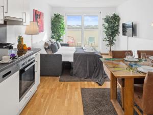a kitchen and a living room with a table at Modern City Apartment near Vienna Central Station in Vienna