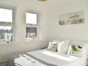 a white bedroom with a bed and two windows at Apartment 2 - Uk42623 in Poole +6 photos