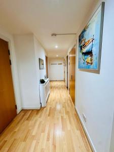 um corredor de um apartamento com piso de madeira e um quadro na parede em Harbour Horizons em Edinburgo