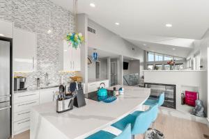 a kitchen with a white counter and blue chairs at Serendipity Beach Retreat Entire House in Salisbury Beach +119 photos