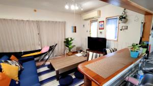 a living room with a couch and a table at Independent House 沖縄VILLA YASUMIBA Okinawa Uruma in Uruma