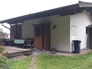 a small white house with a porch and a table at Haus Maria in Oberndorf in Tirol +3 photos
