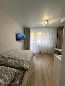 a bedroom with a bed and a television on the wall at Penzion U starého dubu in Louny