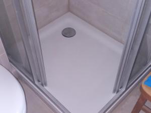 a shower stall with a drain in the floor at Haus Maria in Oberndorf in Tirol