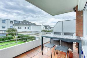 a balcony with a table and two chairs on it at Meerzeit Norderney in Norderney
