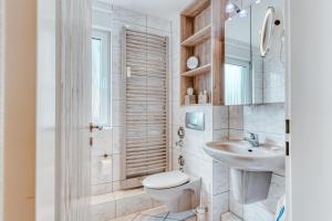 a white bathroom with a toilet and a sink at Meerzeit Norderney in Norderney +18 photos
